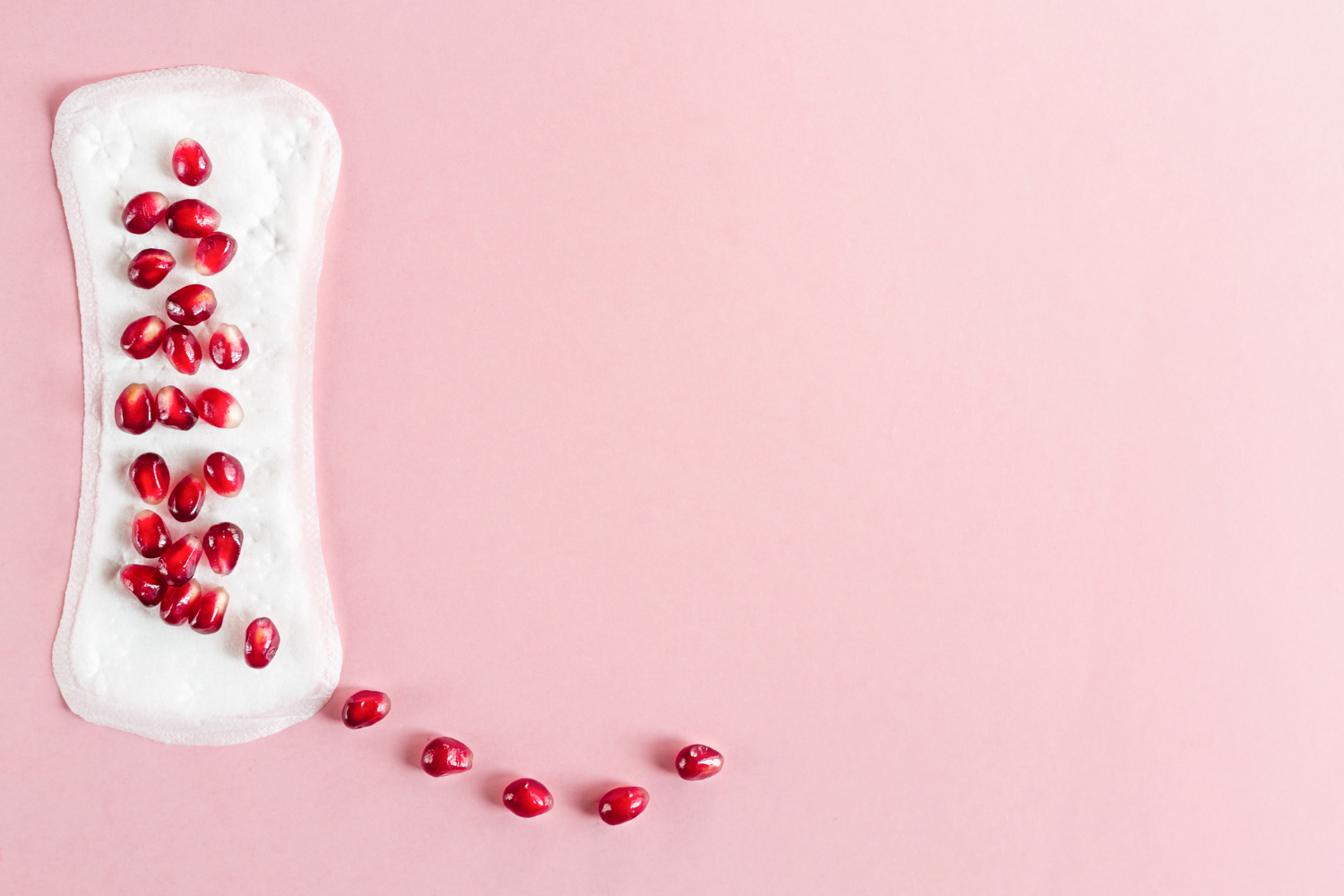 How does the menstrual cycle affect your digestive symptoms; Sanitary pad covered in pomegranate seeds