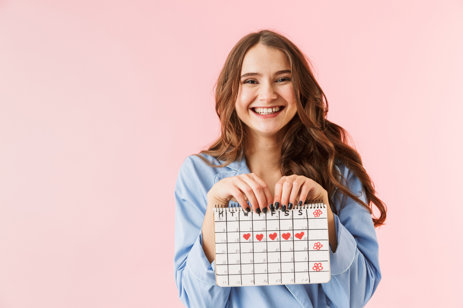 How does the menstrual cycle affect your digestive symptoms; woman with red hair holding a calendar with the days of her menstrual cycle marked